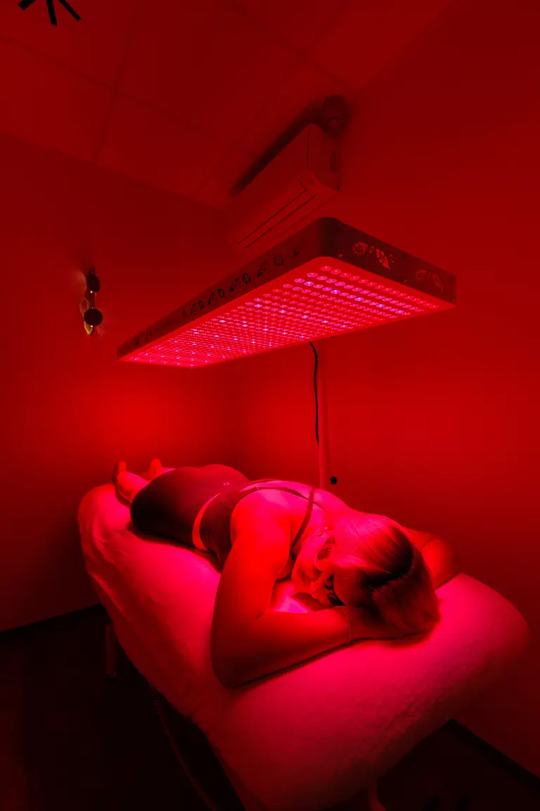 Klientka na lehátku pod panelem Red Light terapie