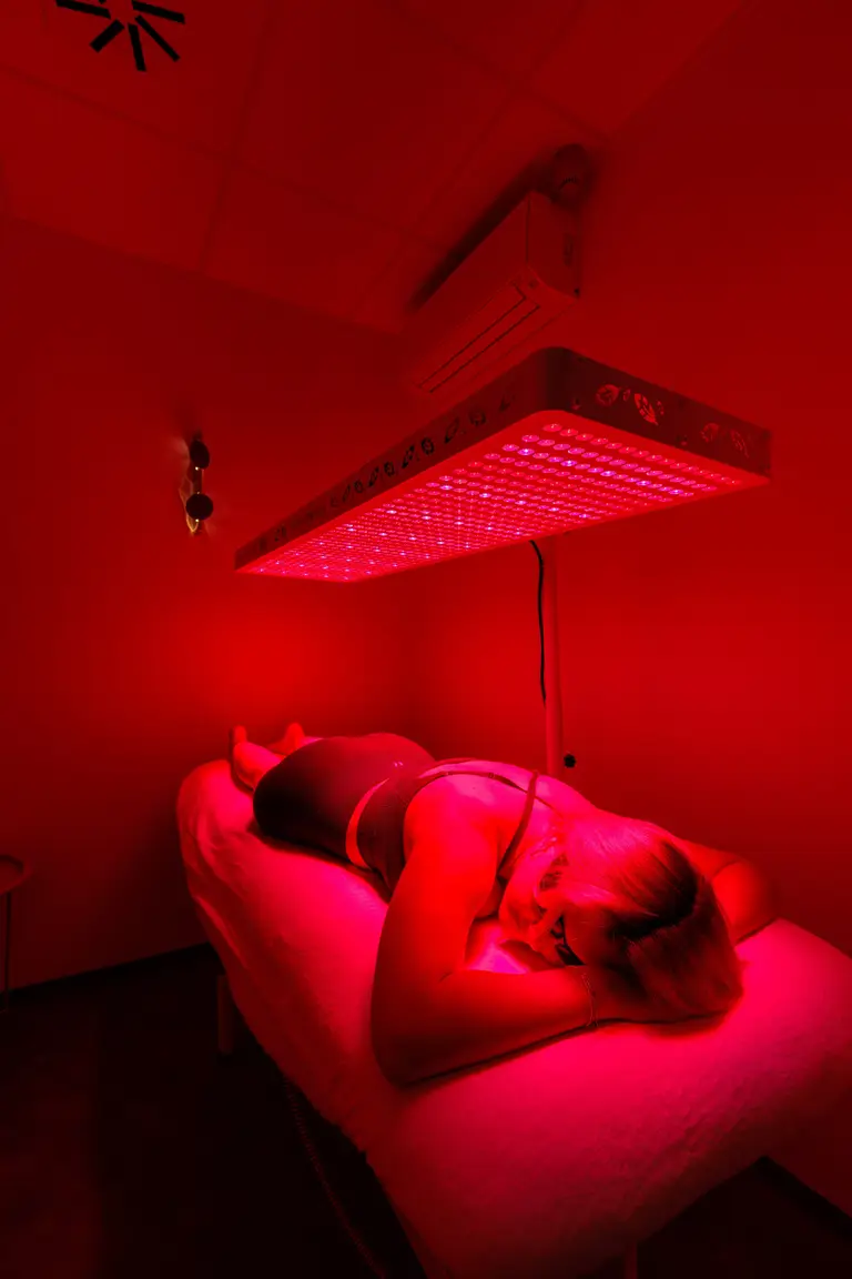 Klientka na lehátku pod panelem Red Light terapie