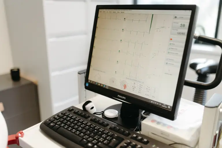 Monitor se záznamem zátěžového EKG vedle ergometru