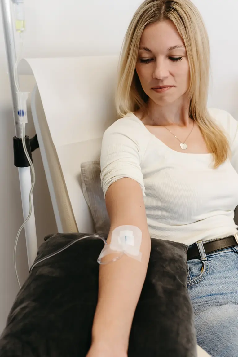 Pacientka se zavedenou kanylou odpočívá v infuzním křesle